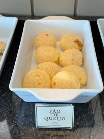 Travessa de pão de queijo, com a plaquinha na bancada