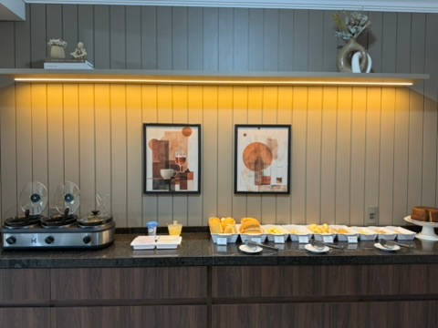 Balcão do café da manhã montado, com as travessas e os quadros