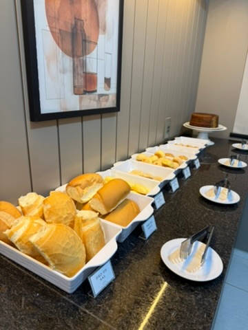 Bancada do café com as travessas de pães em fila