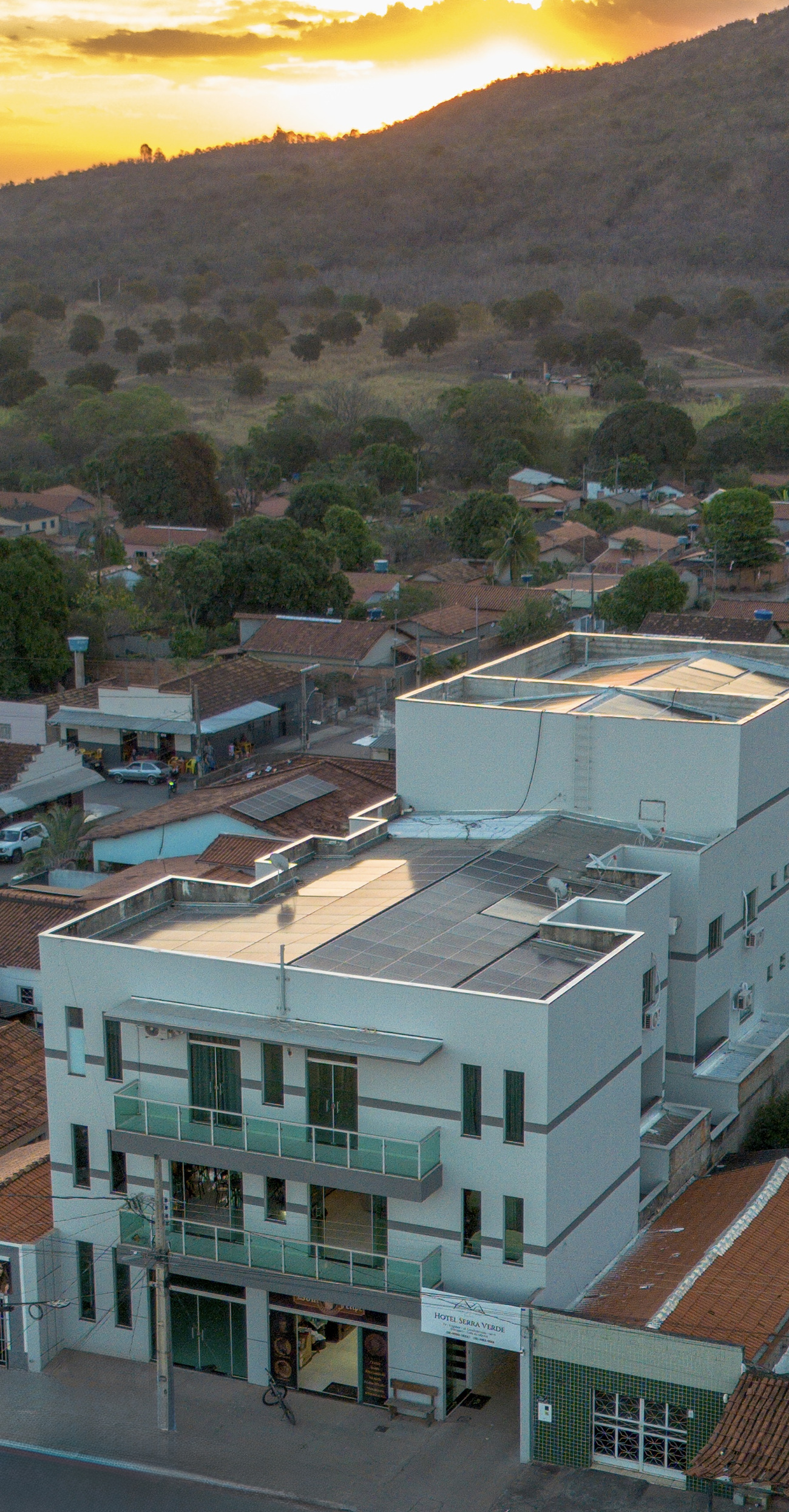 A frente do Hotel Serra Verde no fim da tarde, com o sol se pondo atrás da serra de Brasilândia de Minas