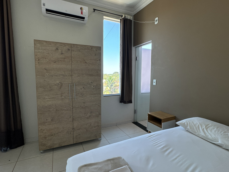 Cama de casal ao lado da janela