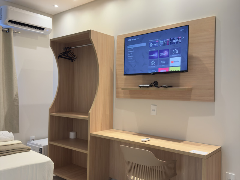 Painel de madeira com televisão, guarda-roupa e escrivaninha