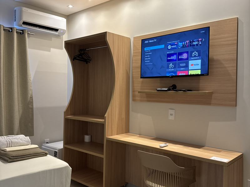 Guarda-roupa, escrivaninha e televisão do apartamento queen