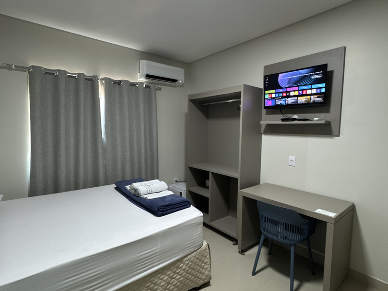Apartamento queen com cama de solteiro e televisão