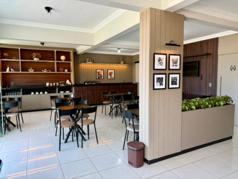 Salão do café da manhã visto da entrada, com a coluna de quadros