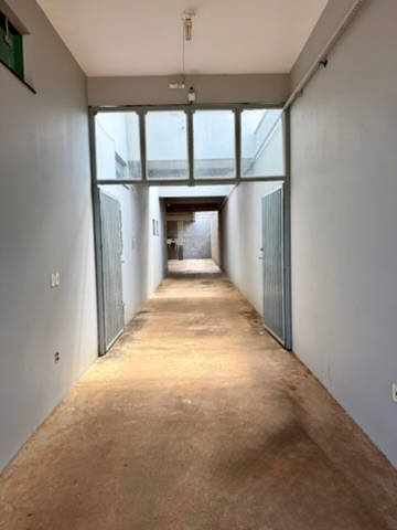 Garagem coberta do hotel, com portão ao fundo