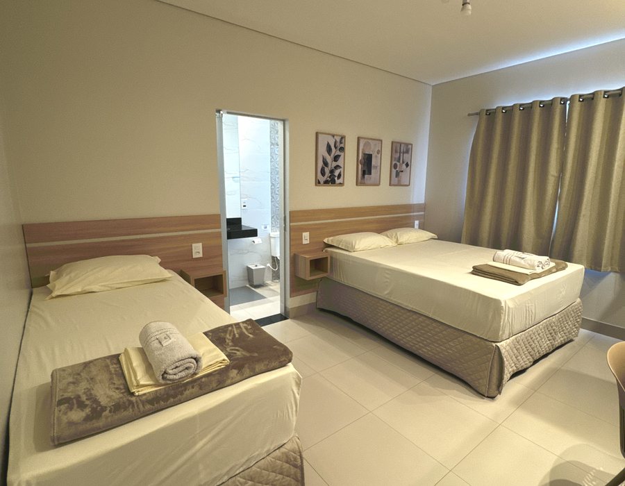 Apartamento com duas camas e painel de madeira